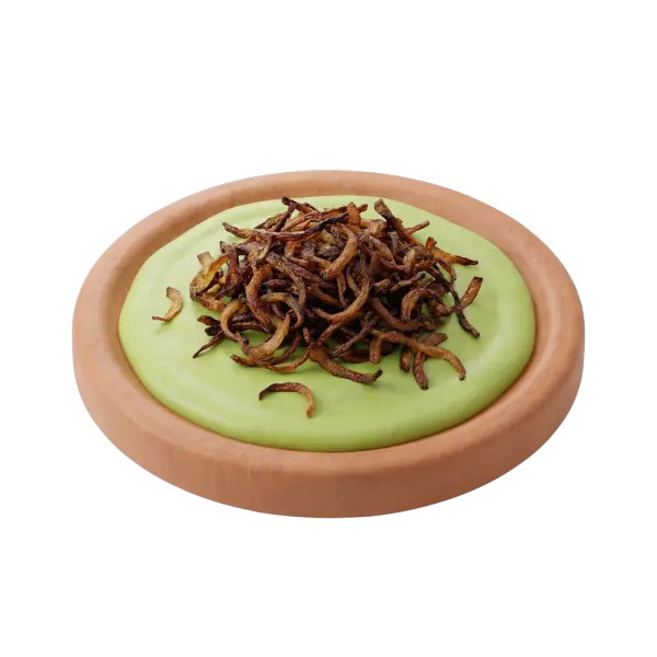 3D render of a terracotta bowl filled with a smooth pale-green fava bean dip, topped with a heap of crispy fried onions; isolated on a black background. Visible textures include the creamy dip surface and the crunchy browned onion strands.