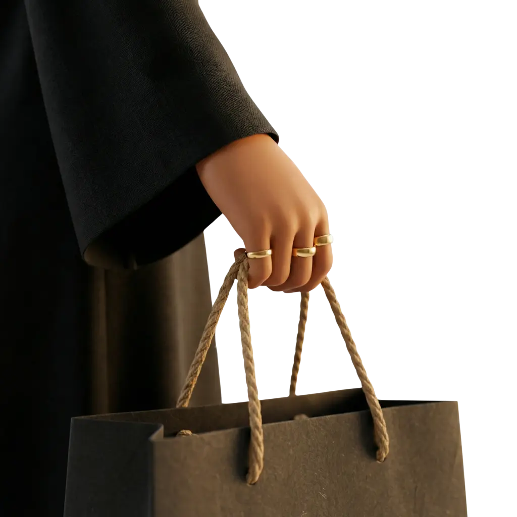 3D render of a matte black textured paper shopping bag with braided rope handles, held by a stylized hand wearing gold rings and a dark fabric sleeve, isolated on a transparent background.